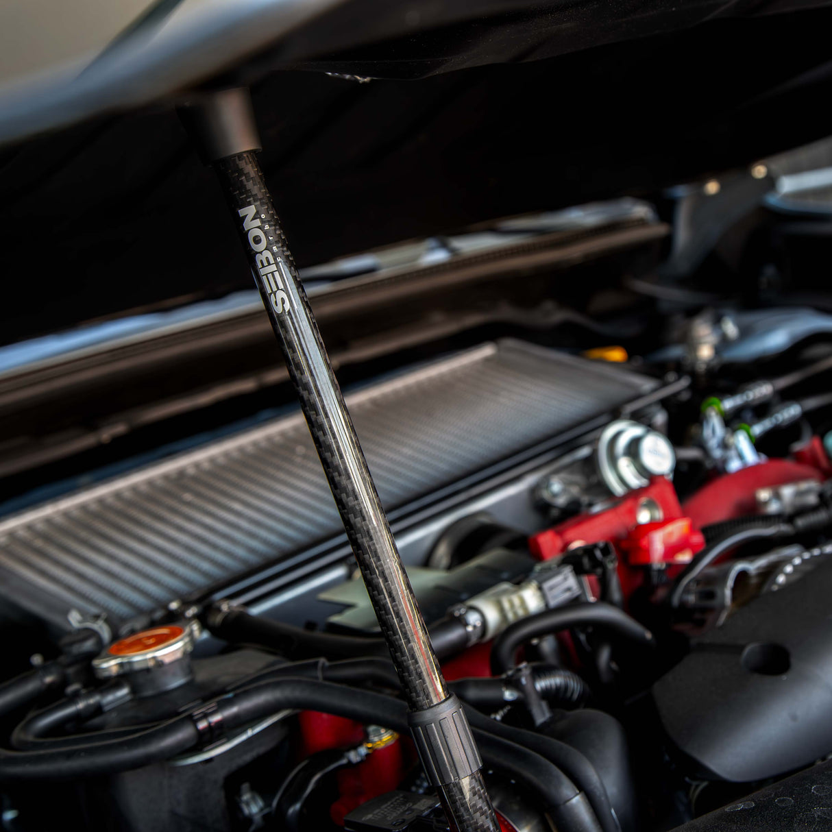 Carbon fiber hood prop with Seibon logo