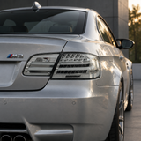 Close-up visualization of clear LED tail lights on a silver BMW E92 M3 coupe